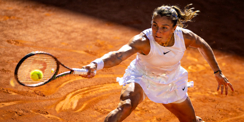 网球运动员在红土场上奋力击球的专业姿态